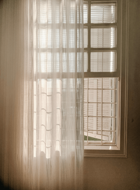 Textured sheer curtain filtering warm daylight