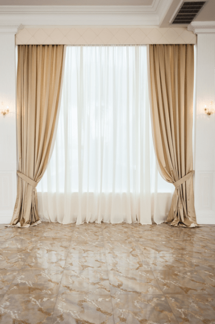 Layered beige drapery and white sheer curtains in an elegant room