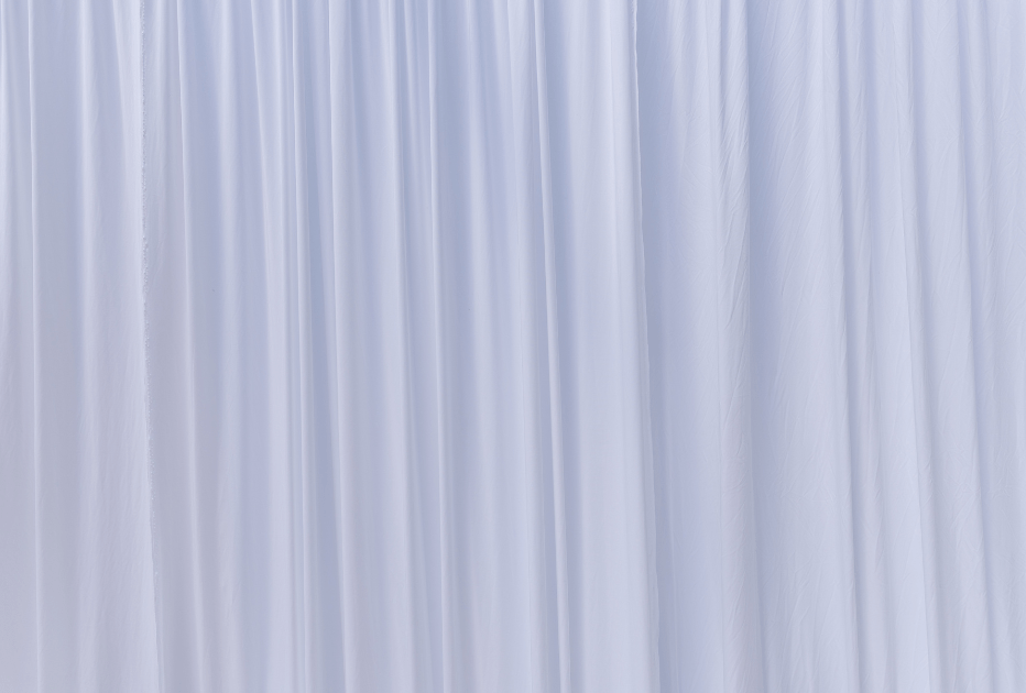 Close view of softly folded white curtain fabric