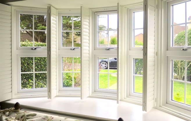 Cafe-height shutters fitted to the lower windows of a bright bay window