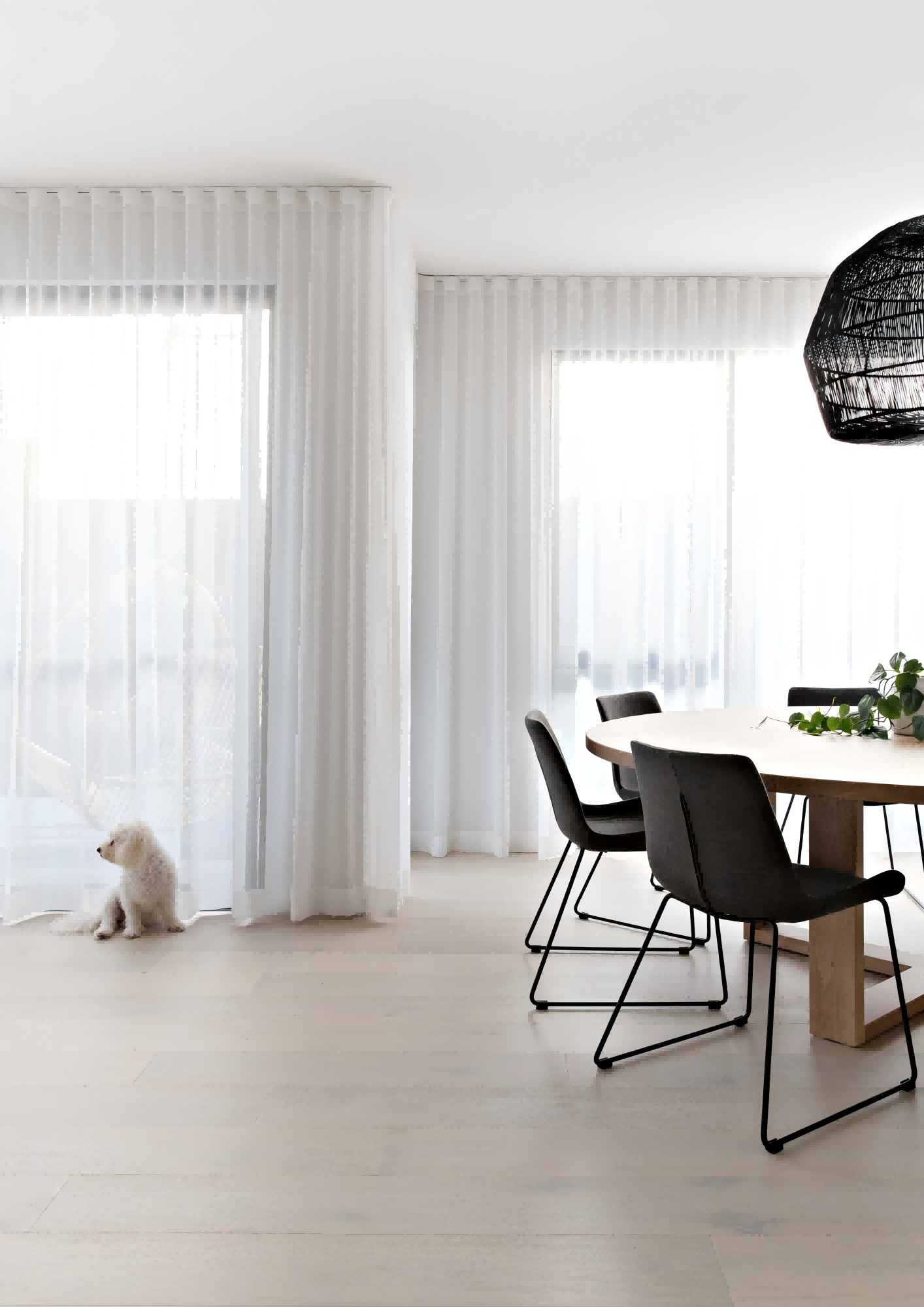 Custom floor-to-ceiling sheer curtains in a bright dining room