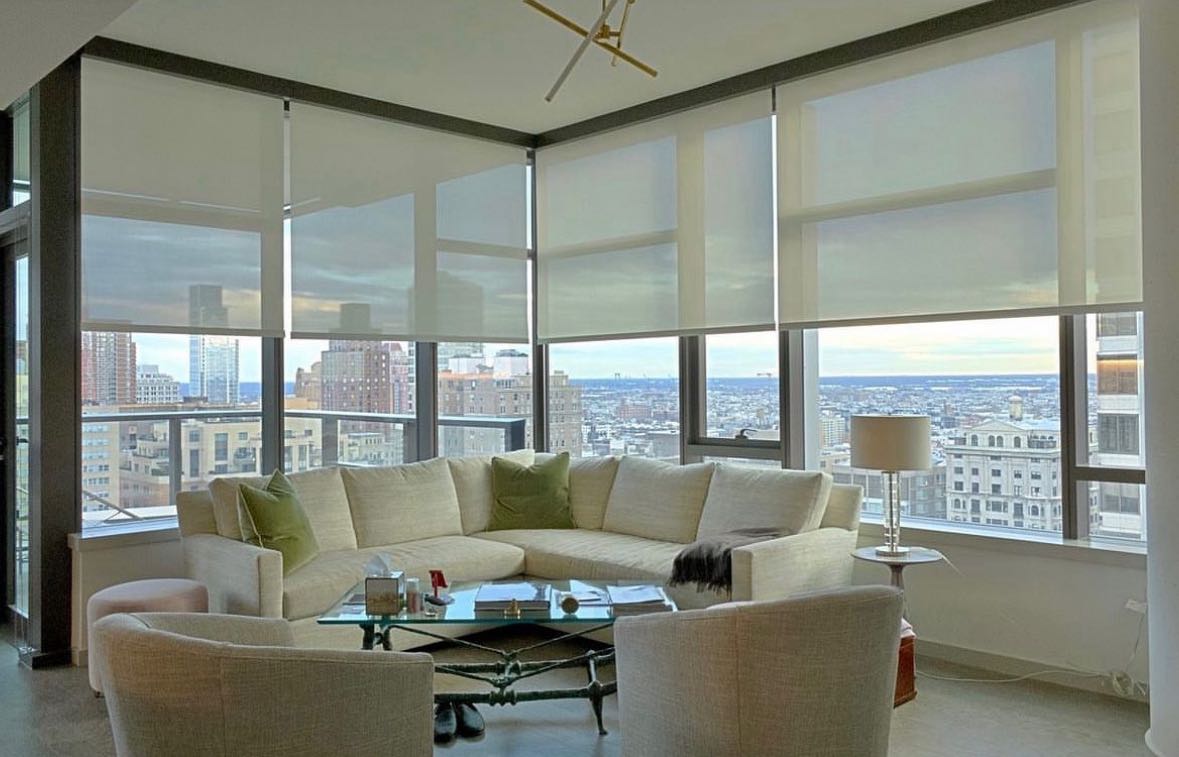 Solar shades across a bright city-view living room