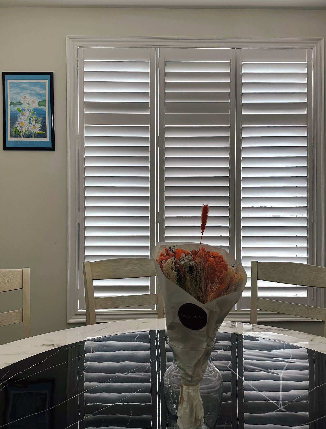 White full-height vinyl shutters on a dining-room window