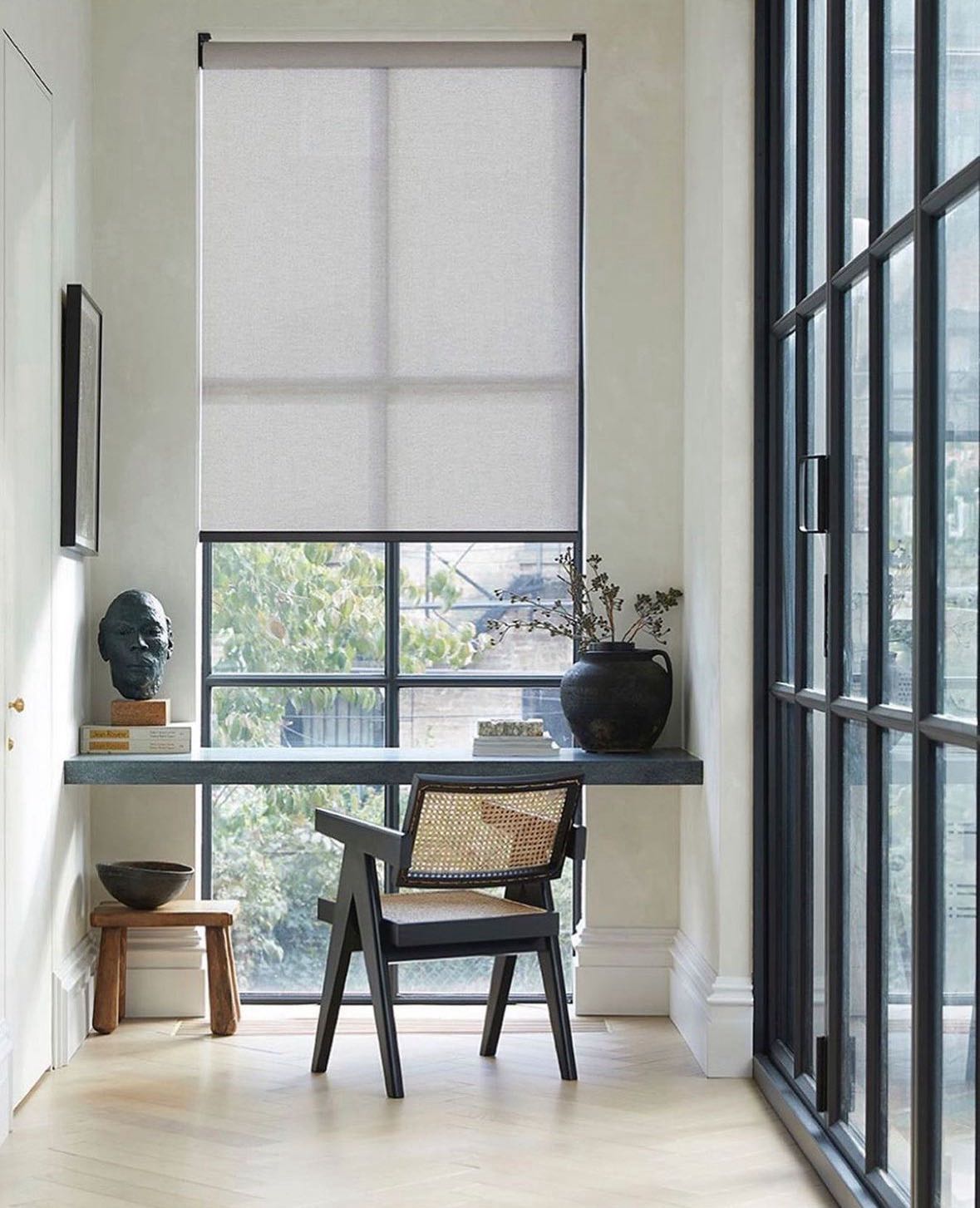 Solar roller shade filtering daylight beside a home office.